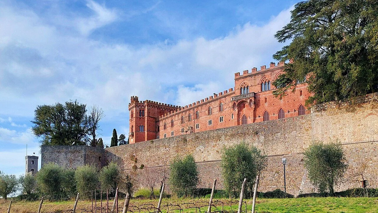 Il Castello di Brolio in mattoni rossi sopra le mura, fra gli olivi