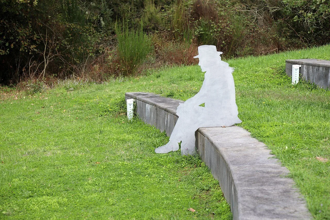 Una scultura bianca a forma di figura seduta lungo il percorso del parco